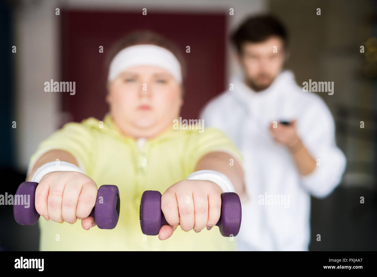 Grasso donna allenamento con i pesi Foto Stock