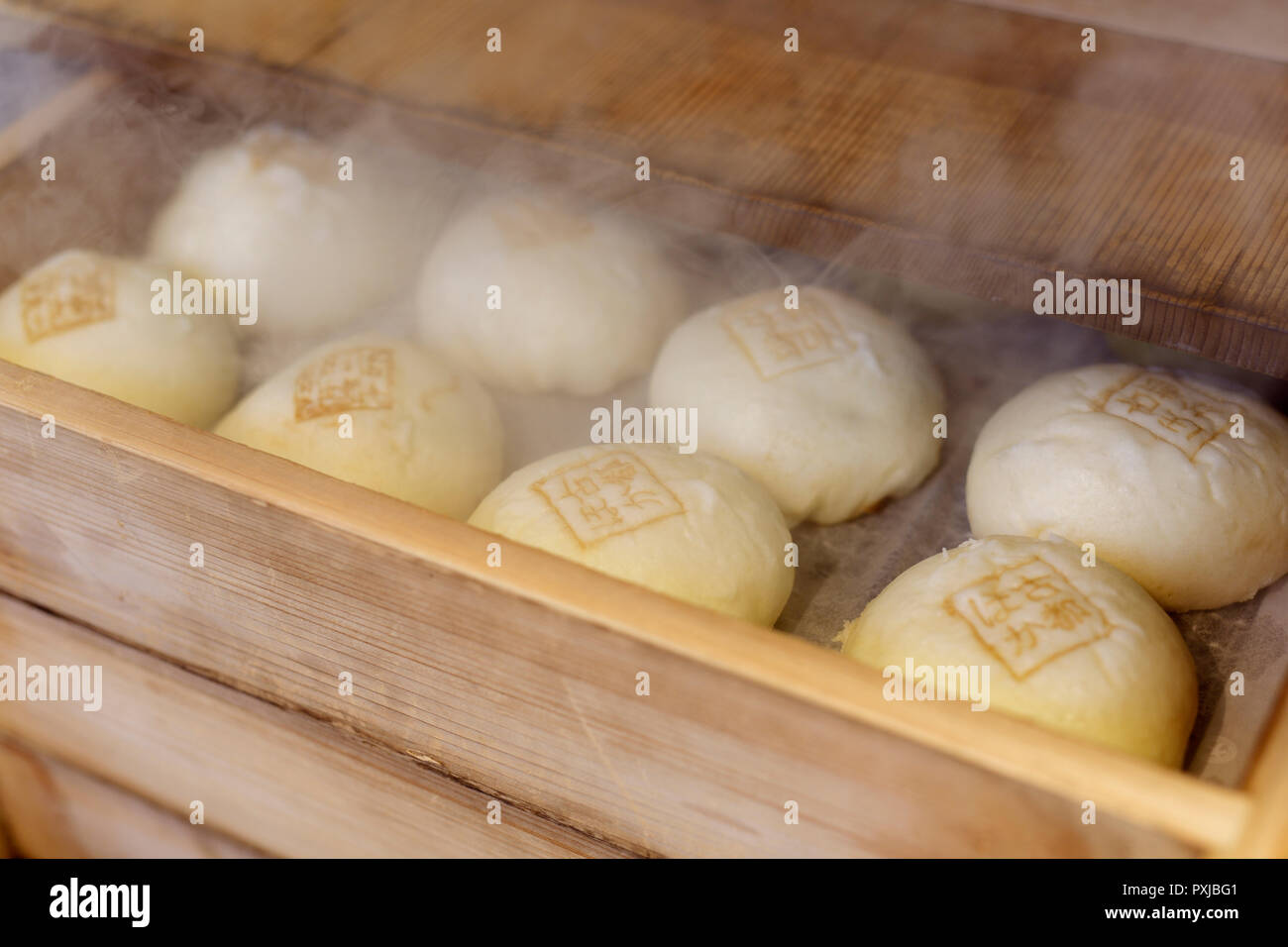 Nikuman, Giapponese di maiale al vapore focaccine, cibo di strada in un tradizionale sistema di cottura a vapore in legno presso un negozio di strada a Kyoto, Giappone Foto Stock