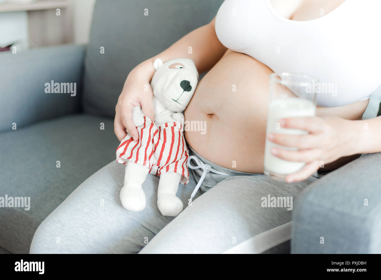 Asian donna incinta con grande pancia. Rilassarsi a casa con il marito. Foto Stock