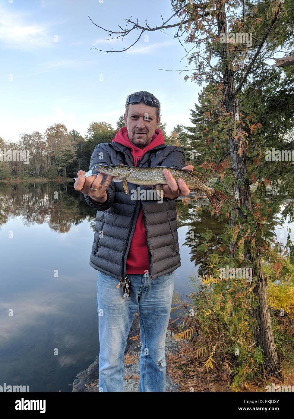 Un giovane uomo con un pesce nelle mani, persone reali, Lifestyle, pesca, all'aperto Foto Stock