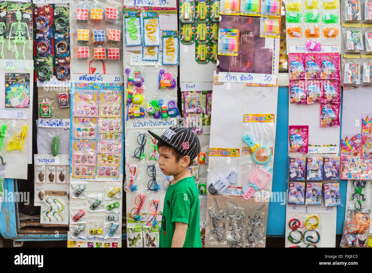 Ragazzo cerca in giocattoli per vendita a convertito furgone VW a comparsa negozio di giocattoli a JingJai Mercato Agricolo, Chiang Mai, Thailandia Foto Stock