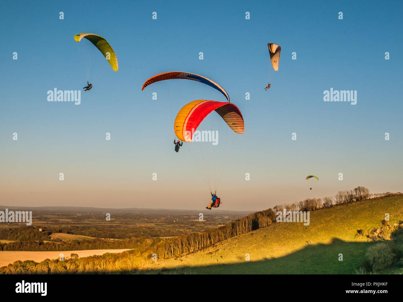 Firle, Lewes, East Sussex, Regno Unito.22 ottobre 2018..un vento decisamente più fresco dal Nord porta piloti di parapendio a Firle Beacon nella bella South Downs. Foto Stock