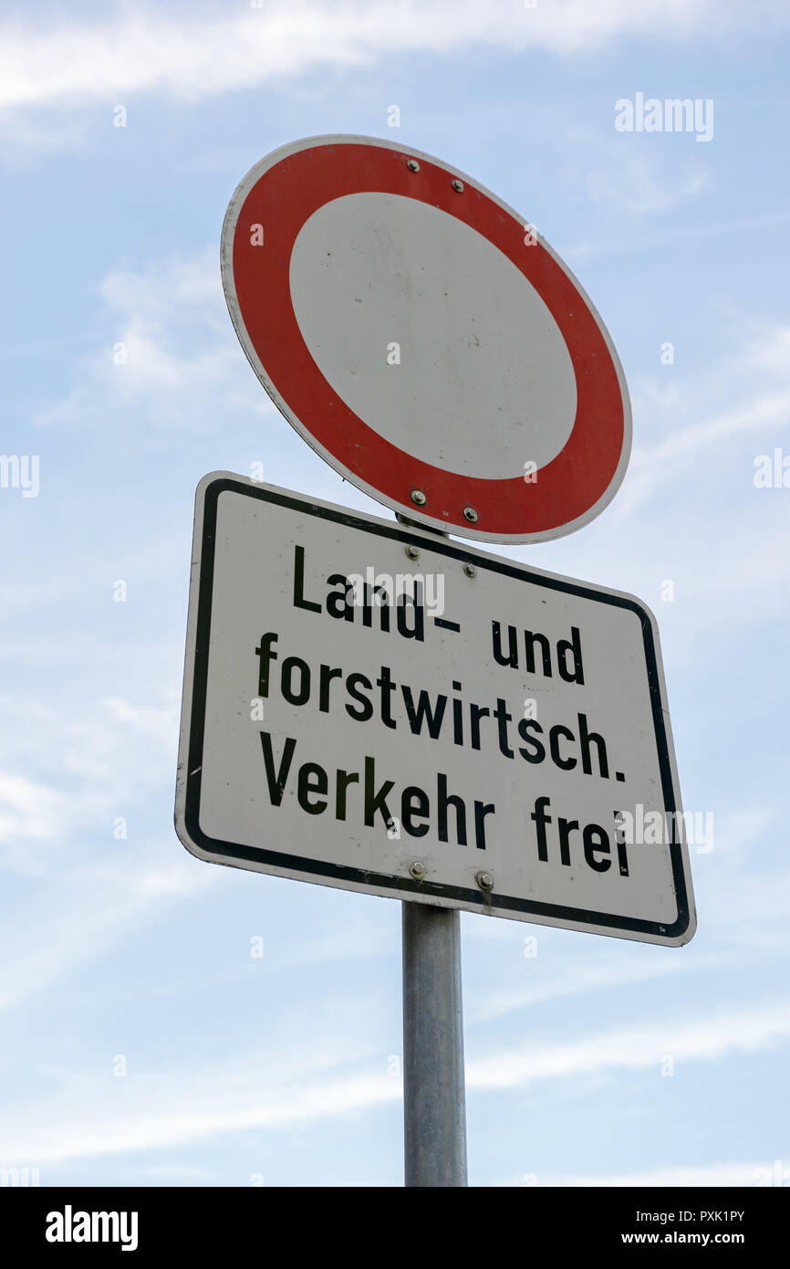 Un cartello stradale che dice - Divieto di transito - tranne quelli agricoli e silvicoli traffico in lingua tedesca nella parte anteriore del cielo blu. Foto Stock