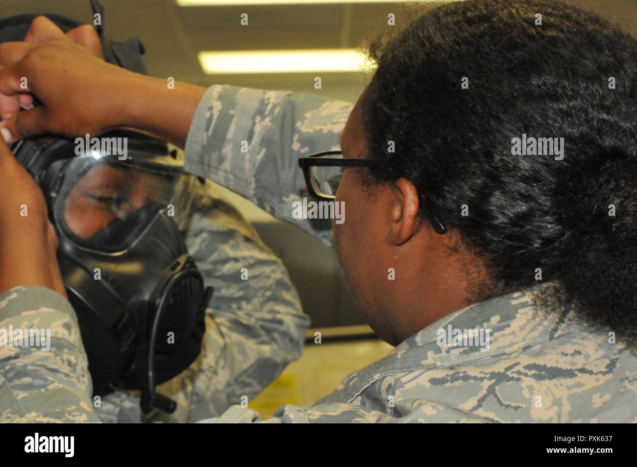 Airman Keyonna Davis (sinistra), 916th squadrone Manutenzione, riceve assistenza da Airman Kiana Ward (destra), 916th Medicina Aerospaziale Squadron, su come correttamente messo su la sua maschera in Seymour Johnson Air Force Base in giugno. Montare la maschera di test sono stati effettuati da aviatori annualmente e un Portacount, una protezione test di valutazione dello strumento, viene utilizzato per testare la durata della maschera a gas.. Foto Stock