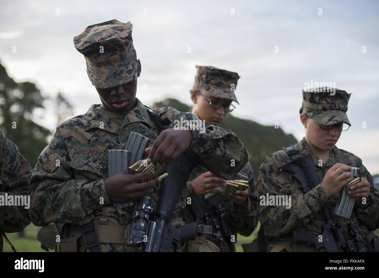 Stati Uniti Marine Corps rct. Angelique Perez (sinistra), plotone 4024, Novembre Company, 4° Battaglione, reclutamento di formazione reggimento, carichi di riviste di Hue città sulla gamma Marine Corps reclutare Depot, Parris Island, S.C., Giugno 6, 2017. Qualifica con la M16-A4 service fucile reclute insegna a comprendere il sistema di armi al fine di mantenere con il concetto di 'Ogni Marine un fuciliere.". Foto Stock