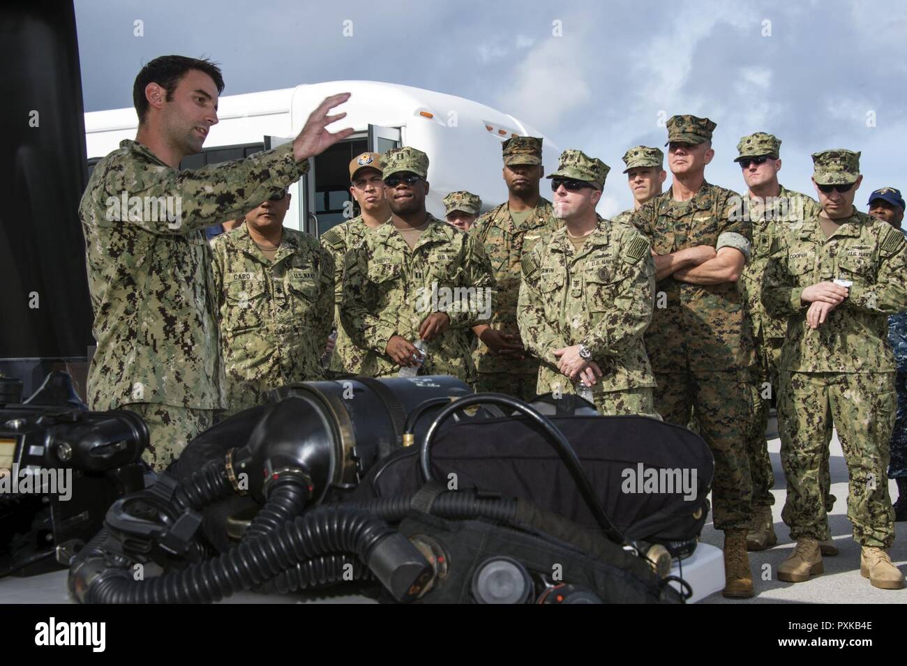 Lt. Andrew Fox, assegnato per l'eliminazione degli ordigni esplosivi unità mobile (EODMU) 5, spiega la funzionalità dei diversi strumenti di EOD alla task force leader durante gli Stati Uniti 7 Il comandante della flotta di training del simposio presso la base navale di Guam Giugno 7, 2017. Il gruppo di leader è in Guam per due giorni di incontri, i giochi di guerra e gli incontri di coordinamento. EODMU 5 conduce il mio contromisure, esplosivi improvvisati operazioni del dispositivo, rende sicuro rischi di esplosione, e disarma underwater esplosivi come mine. Foto Stock