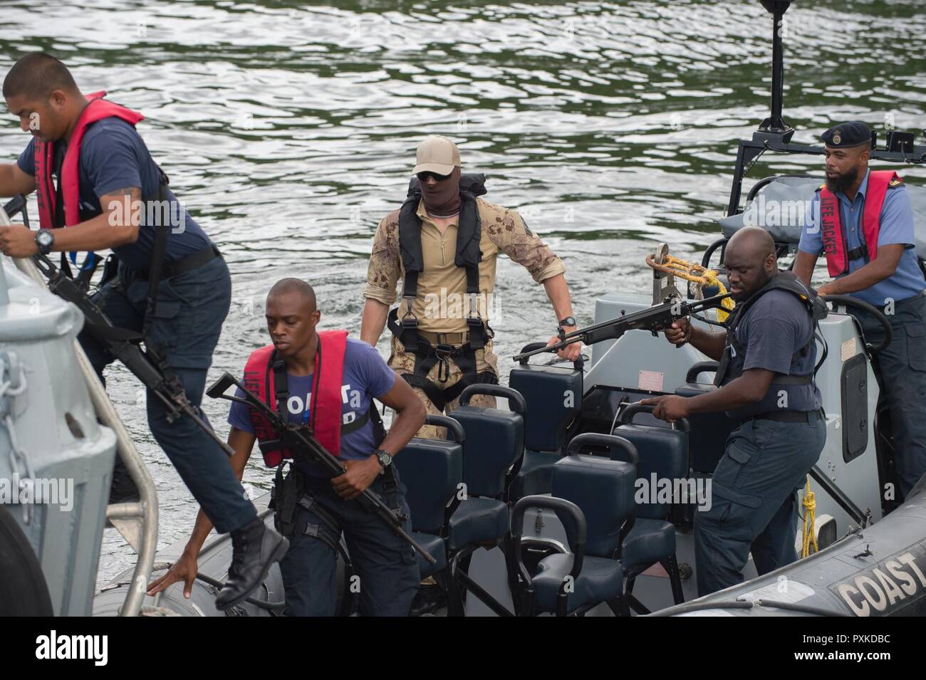 Porto di Spagna, Trinidad - un membro del Maritime tattico Gruppo Operatori (MTOG) osserva i membri del Trinidad e Tobago Coast Guard (TTCG) come essi a bordo di una nave simulato di interesse durante la formazione di imbarco presso la base TTCG in Chaguaramas, Trinidad come parte di esercizio TRADEWINDS 17 il 8 giugno 2017. (Forze canadesi combattere la fotocamera Foto Stock