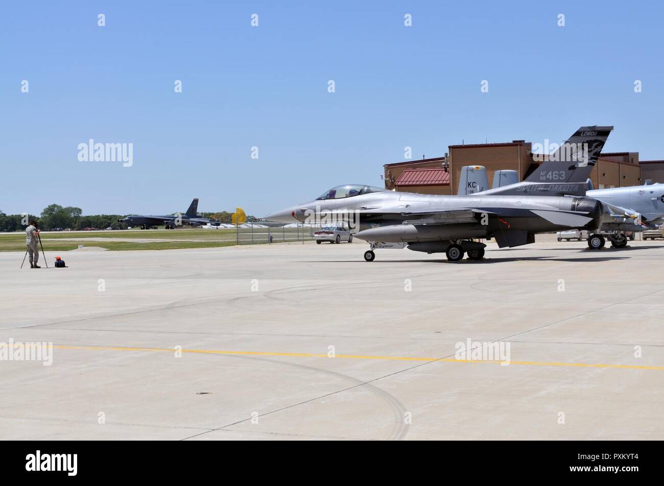 Un F-16 Falcon da 114Fighter Wing, Sioux Falls, SD siede sulla rampa all'Air National Guard base nella città di Sioux, Iowa come un B Stratofortress dal 5° Ala bomba, Minot Air Force Base, ND, taxi verso la rampa in preparazione per un open house che si terrà presso il 185th Air Refuelling ala su Sabato 10 Giugno, 2017. Foto Stock