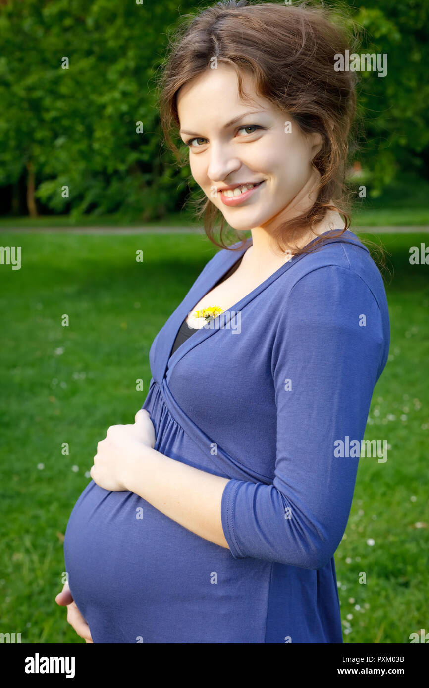 Outdoor ritratto di bella donna in stato di gravidanza Foto Stock