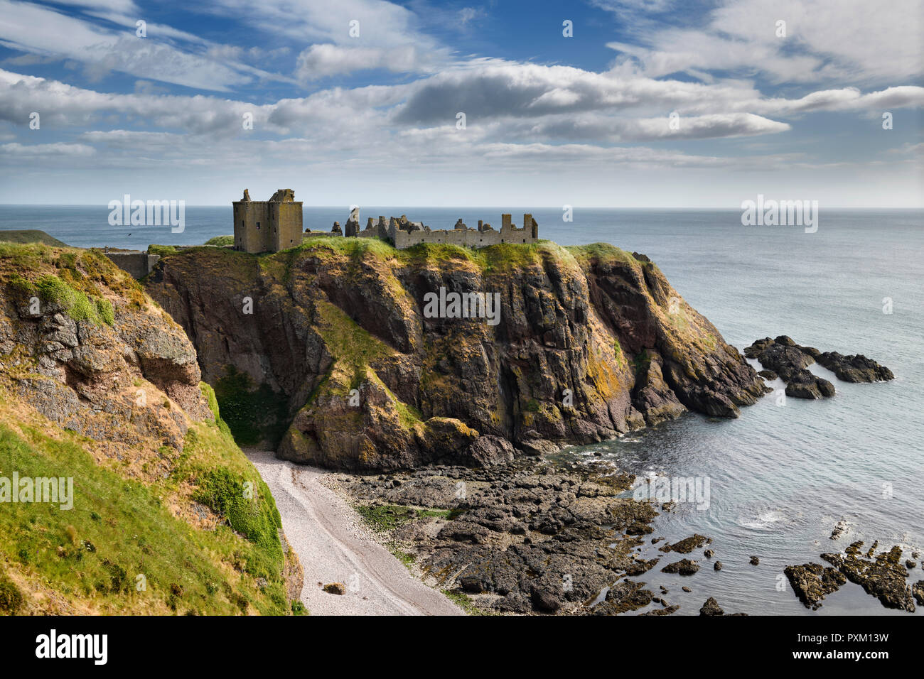 Castello di Dunnottar clifftop medievale rovine nel sole dalla rupe sopra rocce e spiaggia di ciottoli di Old Hall Baia Mare del Nord vicino a Stonehaven Scotland Regno Unito Foto Stock