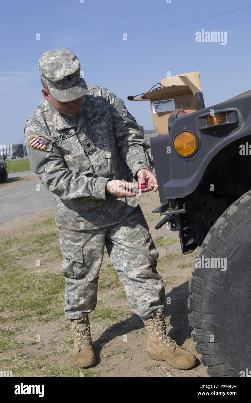 Stati Uniti Army Spc. Kale Raymond, Echo Company, 186th brigata battaglione di supporto, 86a brigata di fanteria combattere Team (montagna), Vermont Guardia nazionale, sostituisce un Humvee è il faro a Fort Drum, N.Y., 10 giugno 2017. Raymond e SPC. Kyle Spaulding siete sono solo la meccanica di supporto del 86º IBCT (MTN) durante un esercizio warfighter condotta per formazione annuale. Foto Stock