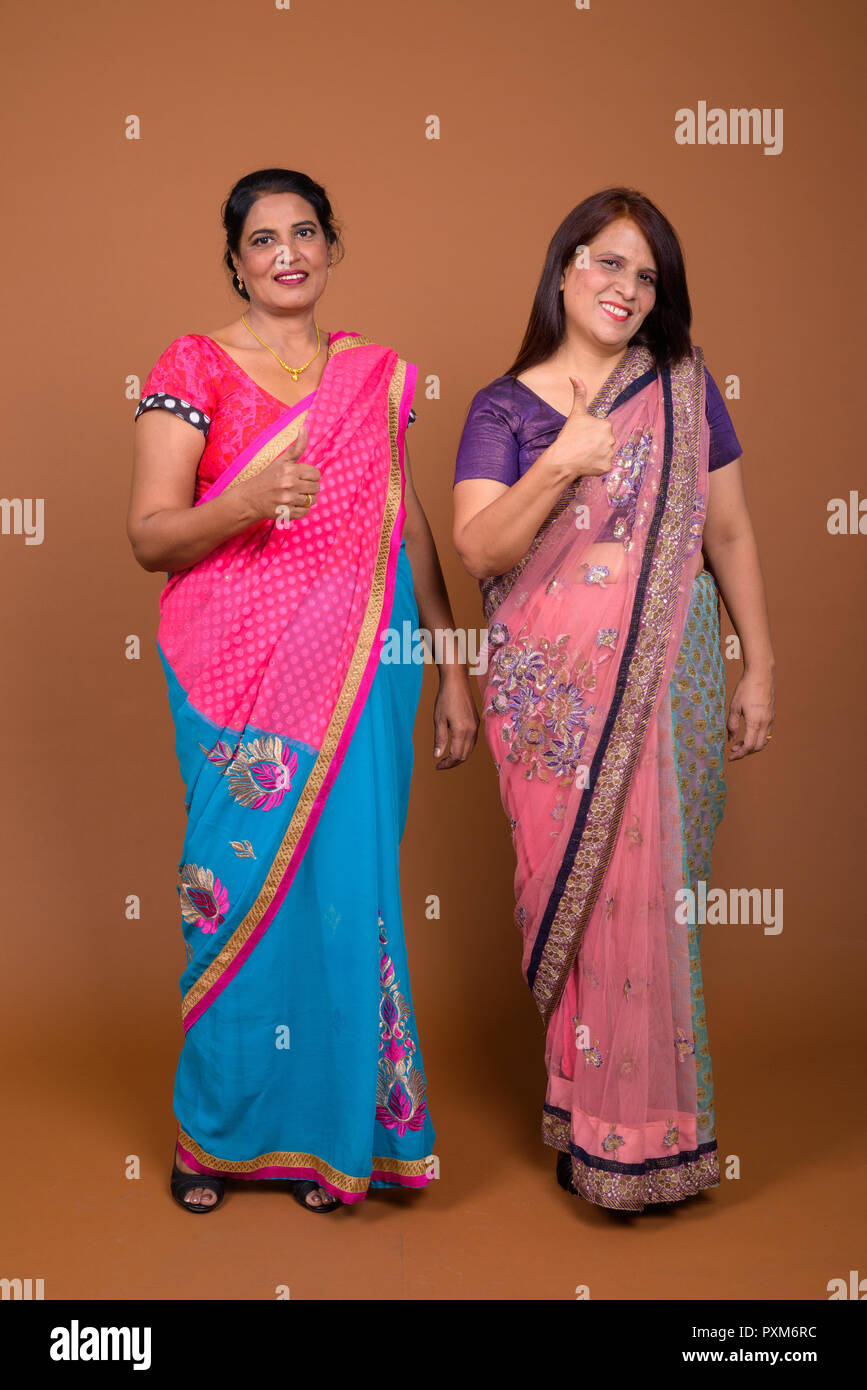 Due felici le donne indiane sorridente e dando pollice in alto Foto Stock