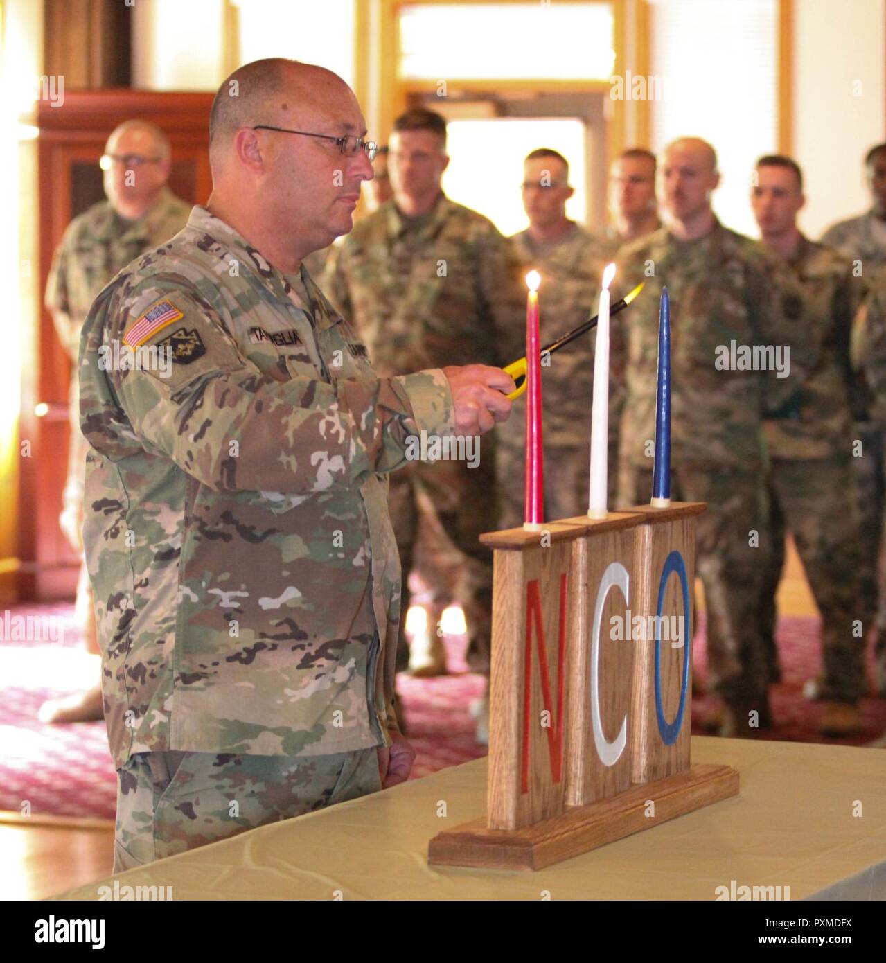 Sfc. Angelo Tartaglia, con la sede del Quartier Generale della Società di combattimento 728th Supporto Supporto battaglione, 213o regionale gruppo di supporto, Pennsylvania Esercito Nazionale Guardia, accende un cero per la induzione di NCO cerimonia di Keystone Conference Center durante la formazione annuale a Fort Indiantown Gap, Pa. Il 14 giugno 2017. Foto Stock