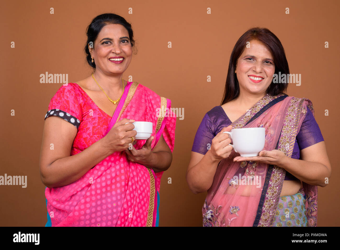 Due coppia donne indiane azienda caffè o tè Foto Stock