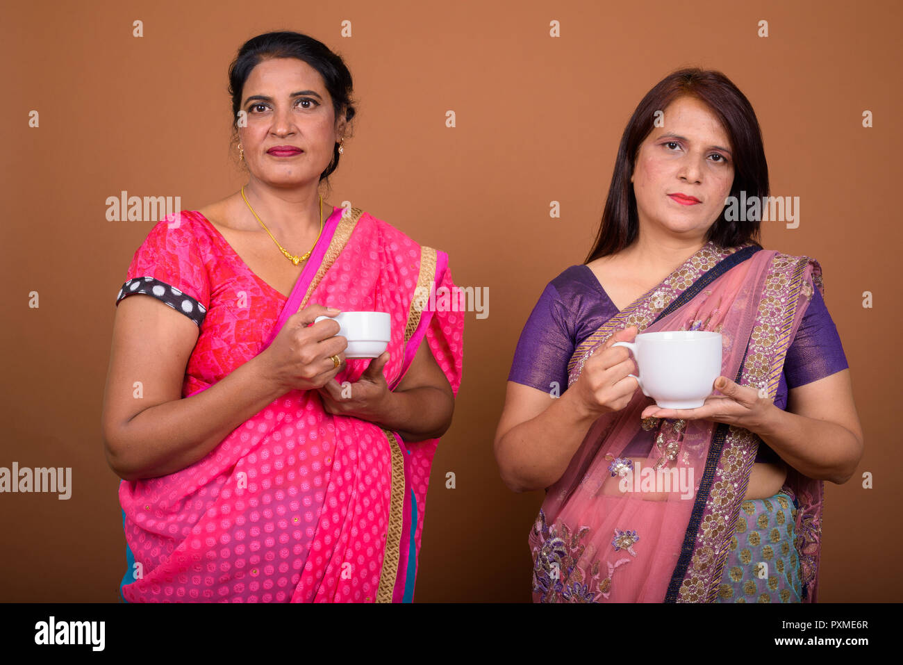 Due coppia donne indiane azienda caffè o tè Foto Stock