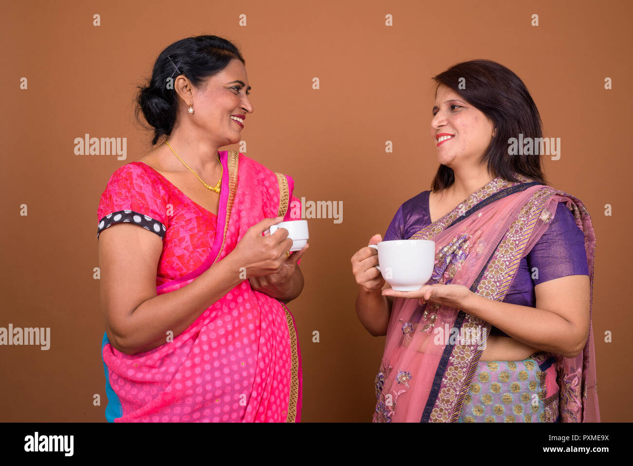 Due coppia donne indiane azienda caffè o tè Foto Stock