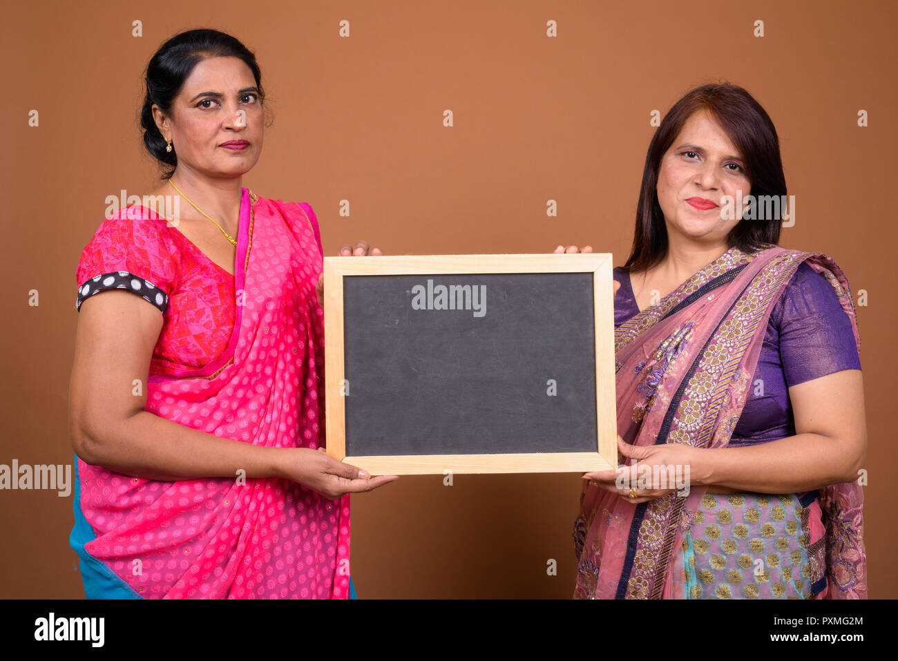 Due donna indiana holding vuoto bordo nero con spazio di copia Foto Stock
