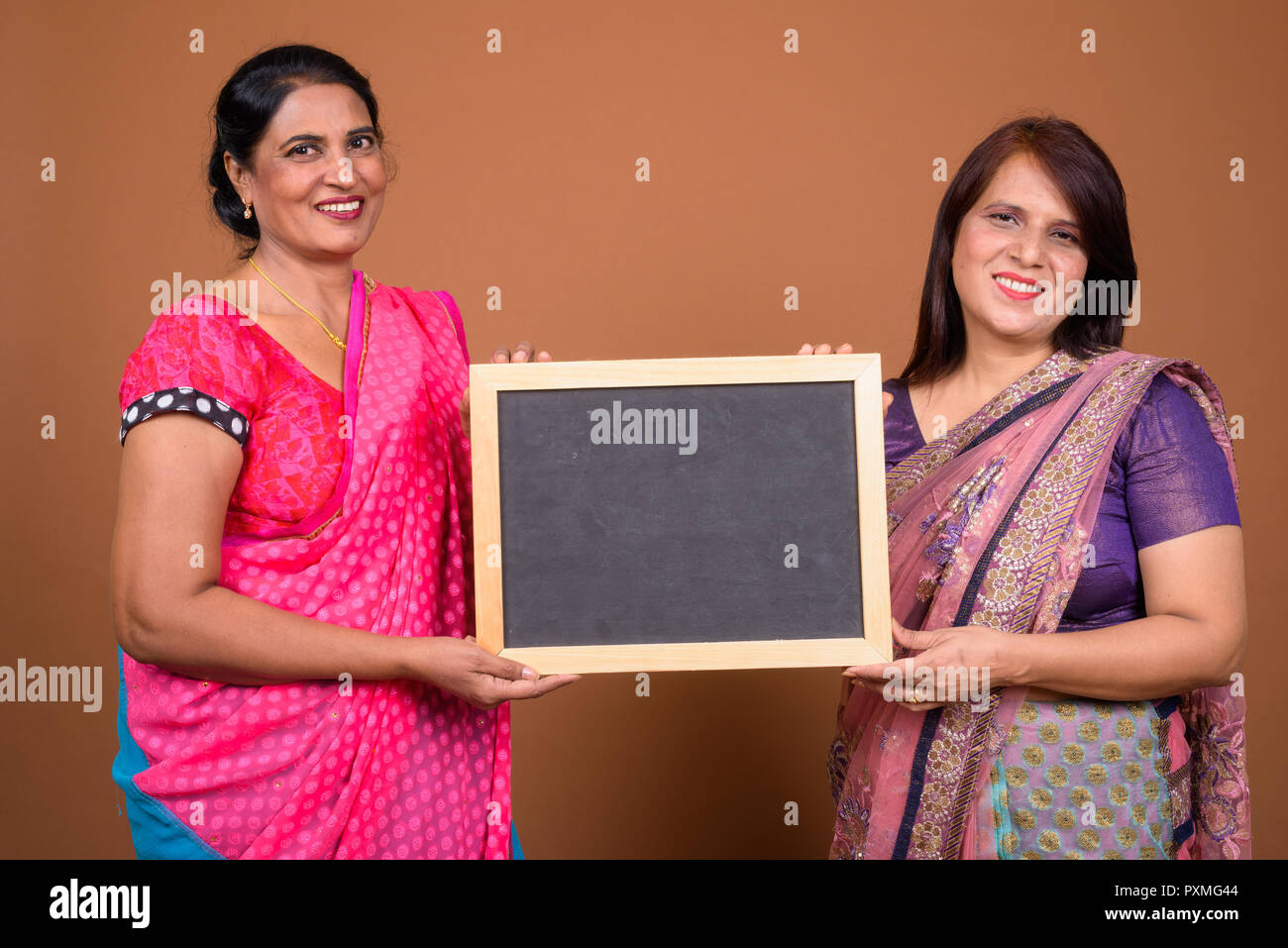 Due felice donna indiana holding vuoto bordo nero con spazio di copia Foto Stock