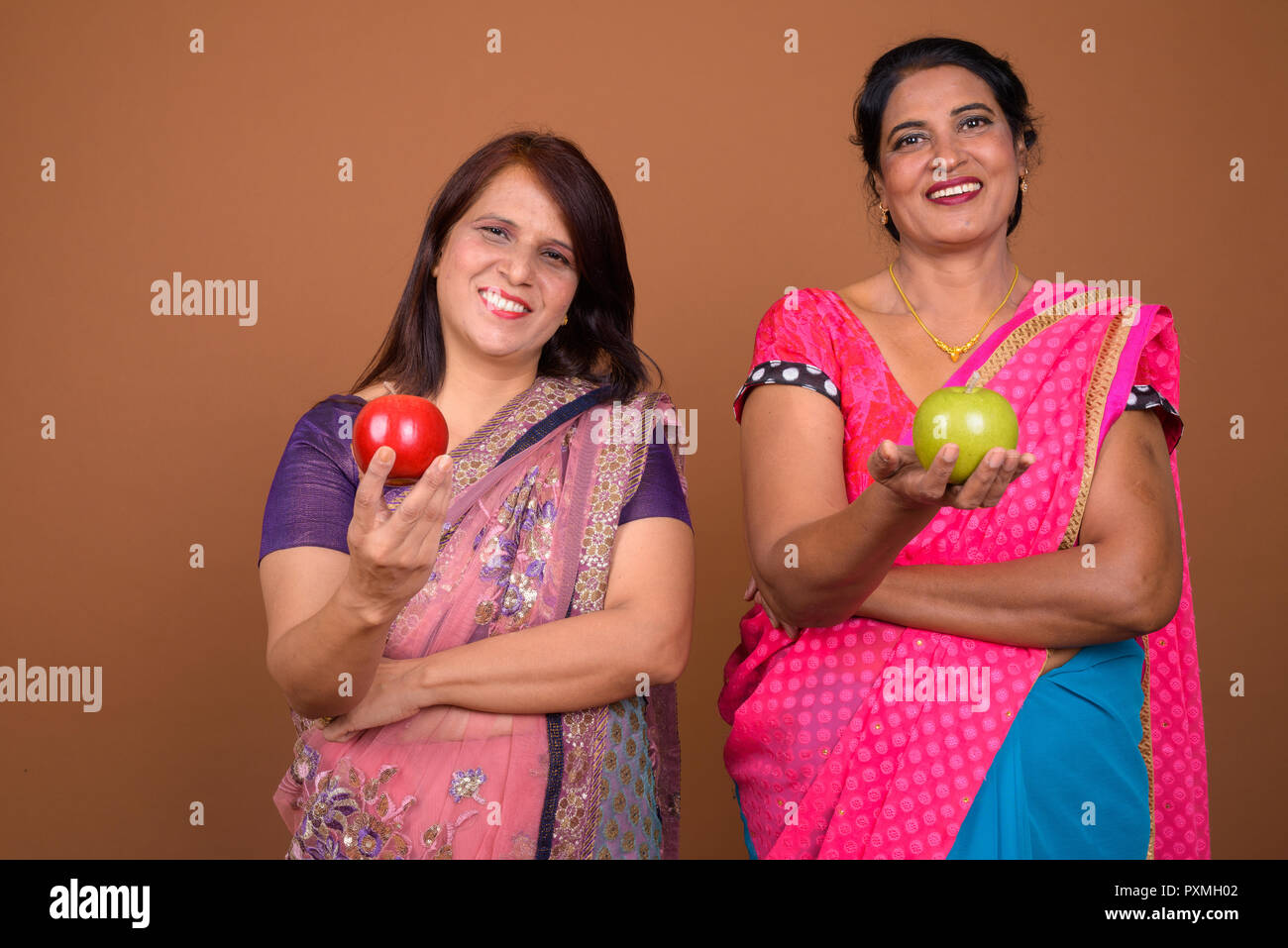 Due felice donna indiana azienda sana frutta apple Foto Stock