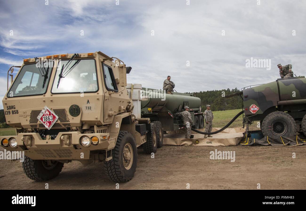 Stati Uniti Soldati con il trasporto 821st battaglione, Esercito degli Stati Uniti si riserva, Kan. e il duecentesimo Engineer Company, South Dakota esercito nazionale Guard refuels una pesante Mobilità Estesa Tactical M978A4 manutenzione carburante carrello durante il Golden Coyote esercizio alla base Custer, S.D., 16 giugno 2017. Il Golden Coyote è un esercizio a tre-fase, scenario di esercizio di condotta condotta in Black Hills del Sud Dakota e Wyoming, quali comandanti permette di concentrarsi sulla missione requisiti essenziali per lo svolgimento delle attività e le attività del guerriero e punte di battaglia. Foto Stock