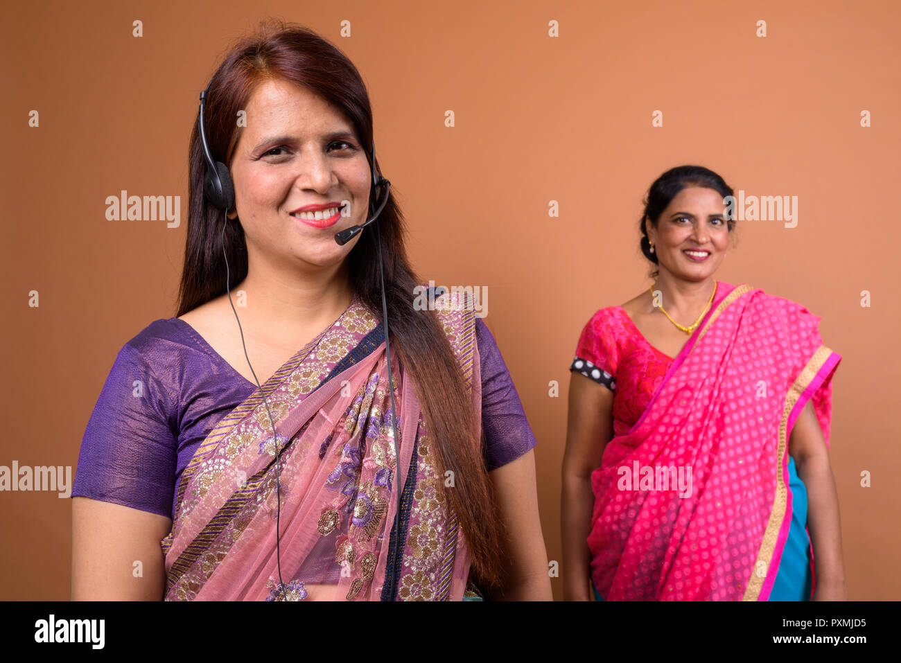Ritratto di felice donna Indiana chiamata rappresentante del centro di indossare le cuffie Foto Stock