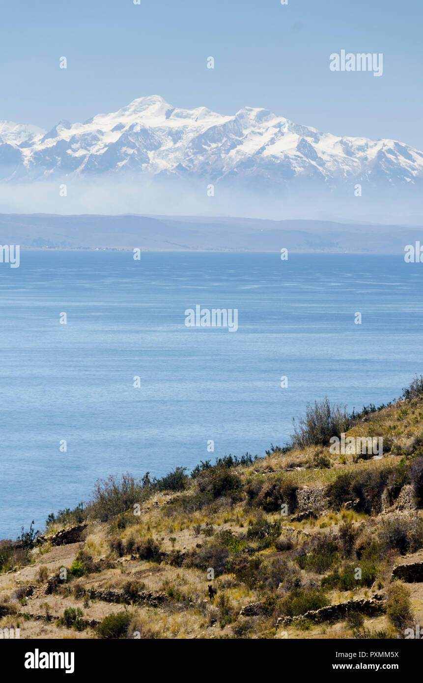 Coperta di neve montagne delle Ande, guardando attraverso il lago Titicaca, il lago Titicaca, dal cantone Sampaya, vicino a Copacabana, Bolivia Foto Stock