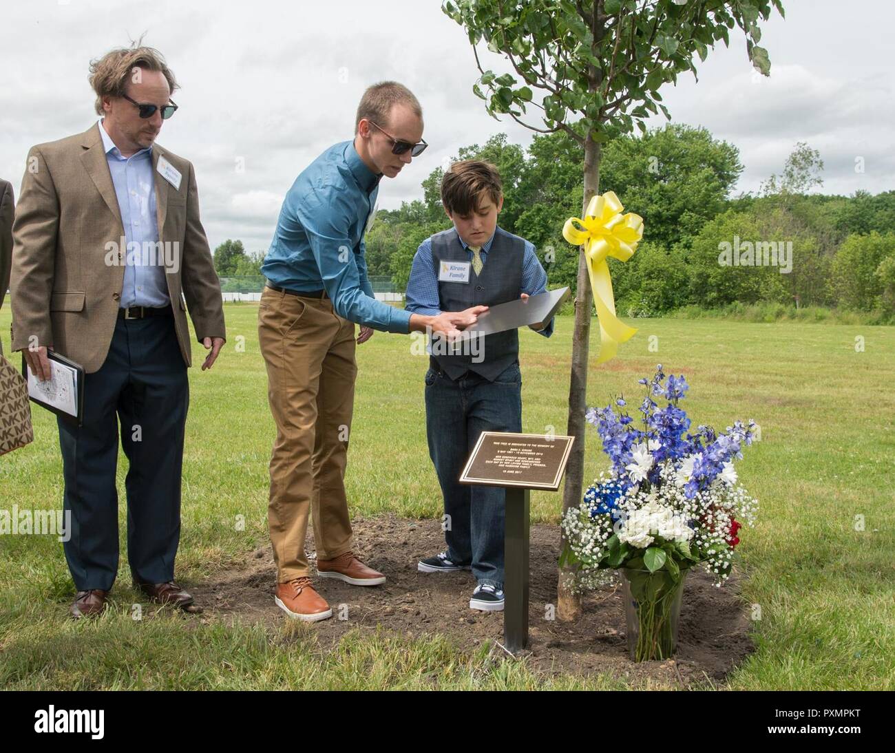 Joe Kirane guardare come suoi figli, Dylen e Ian, svelano una lapide di fronte a una struttura dedicata a sua madre, Dana E. Kirane, durante un parco memoriale Inaugurazione a Hanscom Air Force Base, Massachusetts, Giugno 16. Kirane lavorato presso Hanscom dal 1974 fino al suo pensionamento nel 2006 come i servizi finanziari officer. Onorato anche durante la manifestazione sono stati Dennis "Dennie" Guthrie e pensionati Tech. Sgt. John A. Raynes. Foto Stock