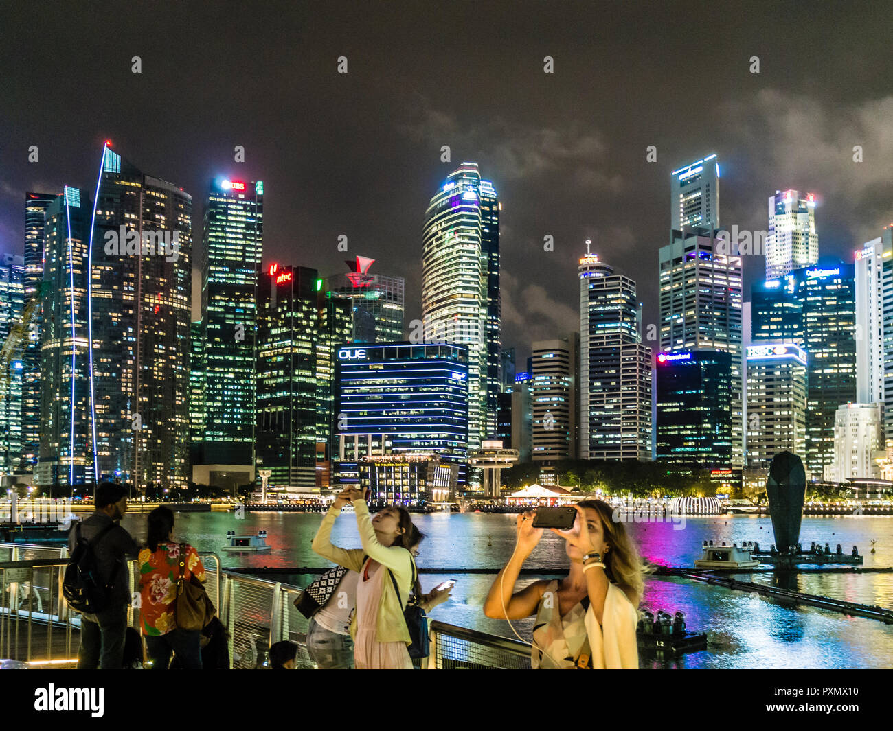 I turisti a Singapore Marina Bay sono a scattare foto e selfies nella parte anteriore dello skyline della città. Foto Stock