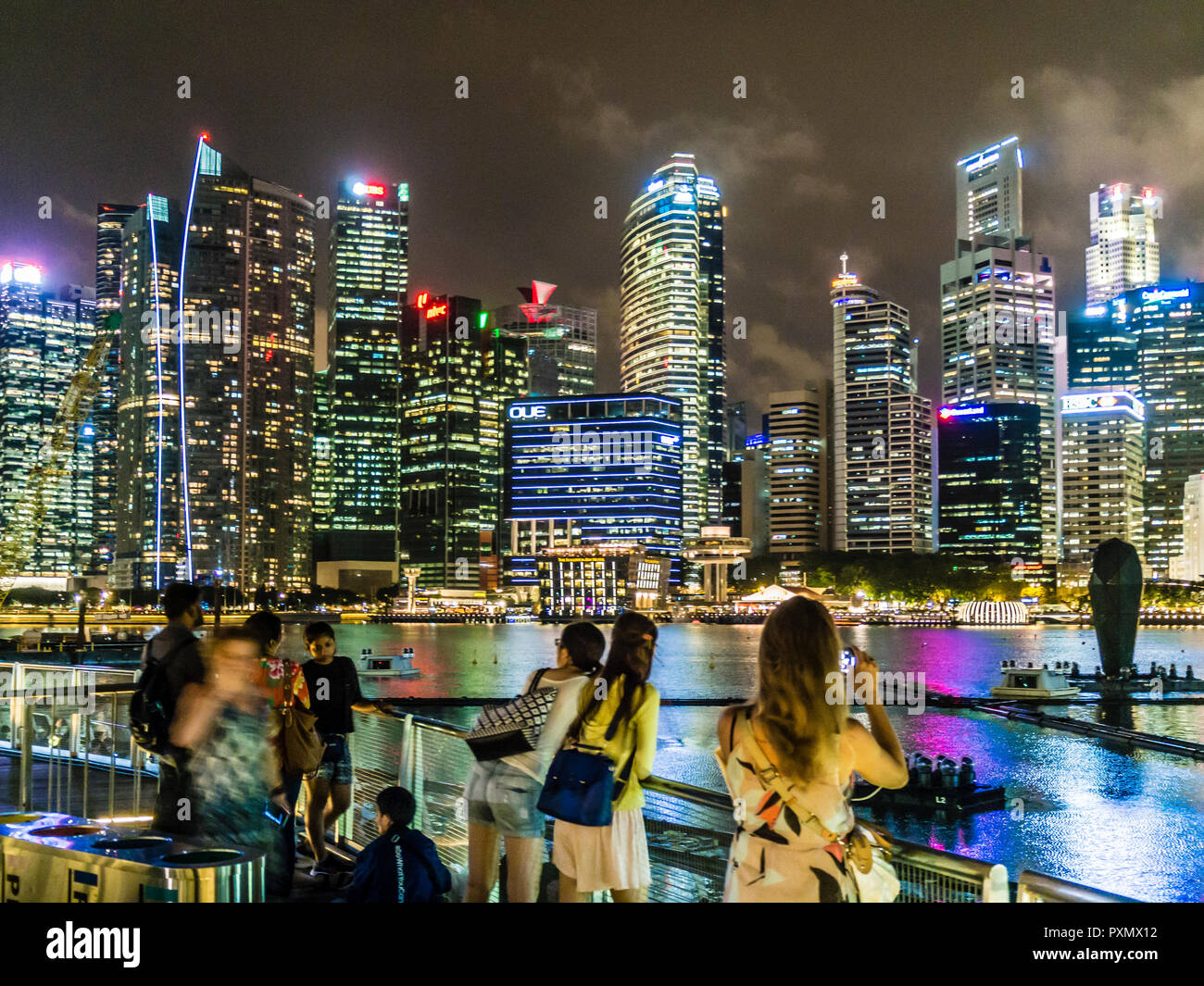 I turisti a Singapore Marina Bay sono a scattare foto e selfies nella parte anteriore dello skyline della città. Foto Stock