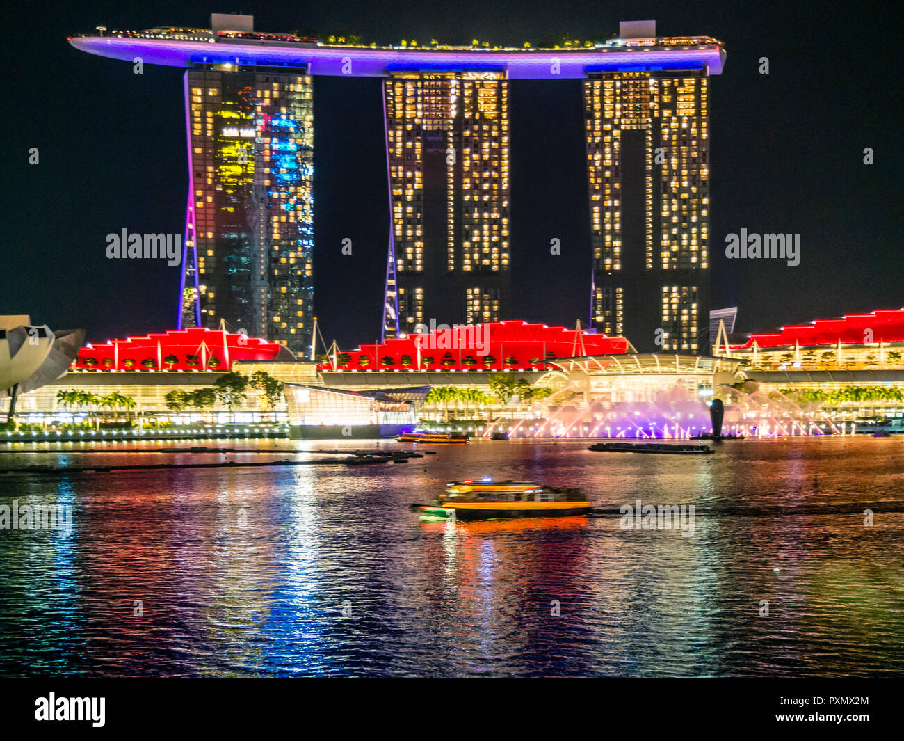 Vista di notte in tutta Singapore Marina Bay verso l'illumina il Marina Bay Sands Hotel. Foto Stock