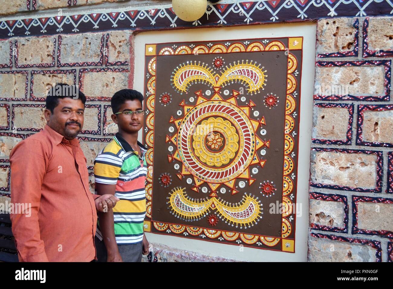 Due uomini/artisti che lavorano sul fango- specchietto arte/arte Lippan che posano per una fotografia al Kutch-Gujarat/India Foto Stock