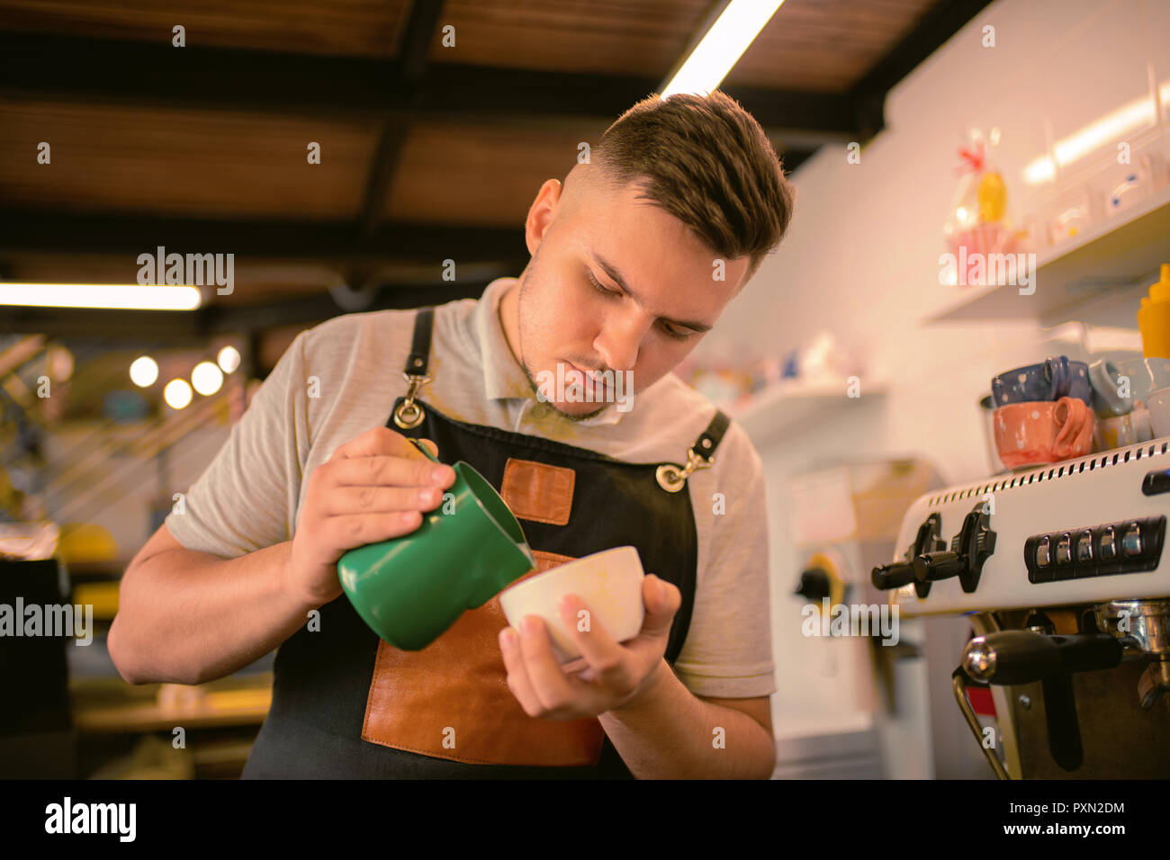 Ritratto di concentrato di barista che la cottura di caffè Foto Stock