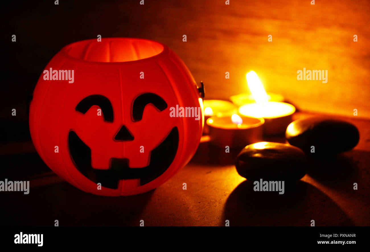 La luce di una candela crescente sul sorriso di zucca decorare per la notte di Halloween Foto Stock