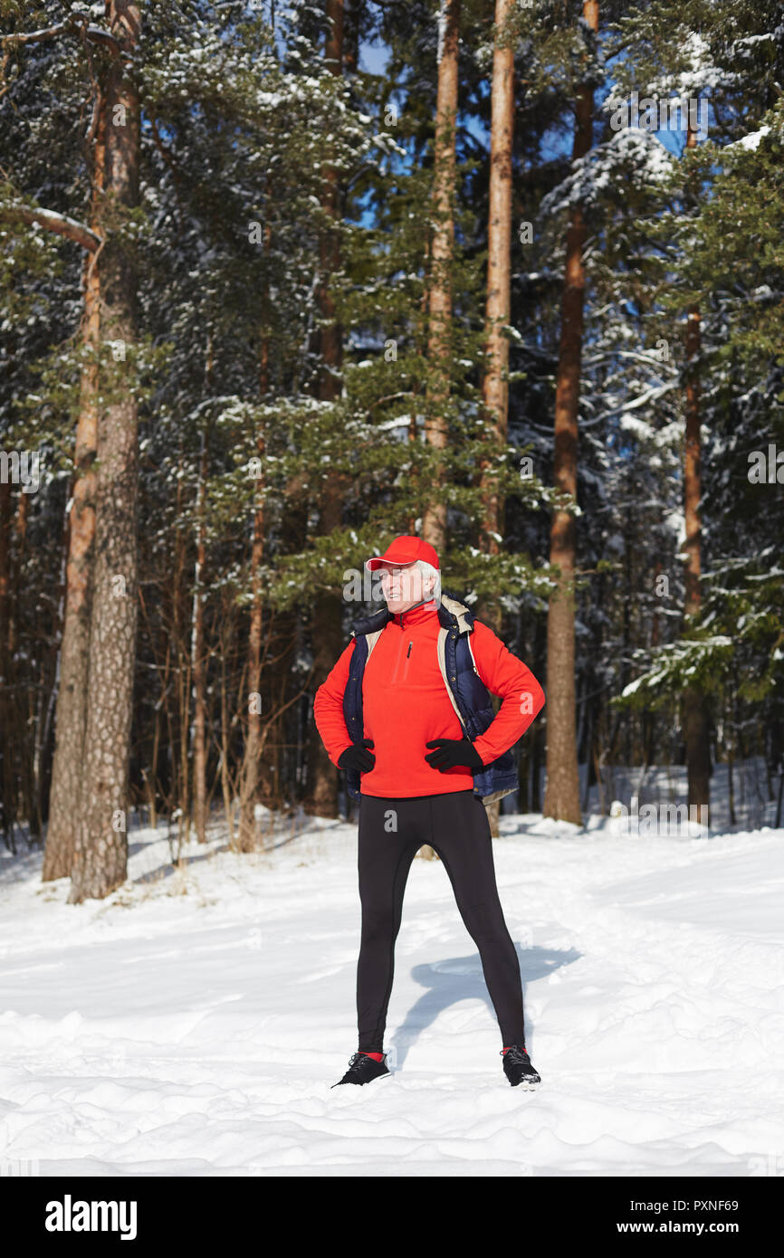Coppia di uno sportivo in piedi in akimbo pongono sul cumulo di neve mentre si esercita nella foresta di inverno Foto Stock
