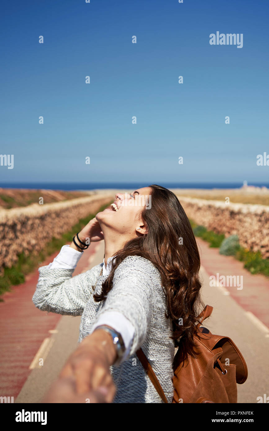 Allegro bruna giovane donna tenendo la mano dell'uomo Foto Stock