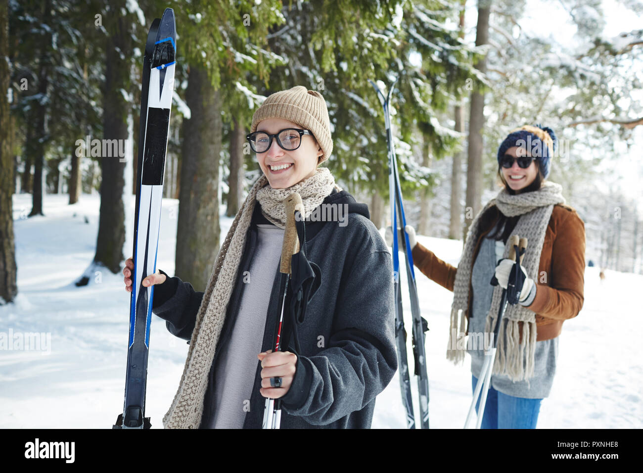 Vita ritratto felice due giovani donne di sci in inverno forest e sorridente in telecamera Foto Stock