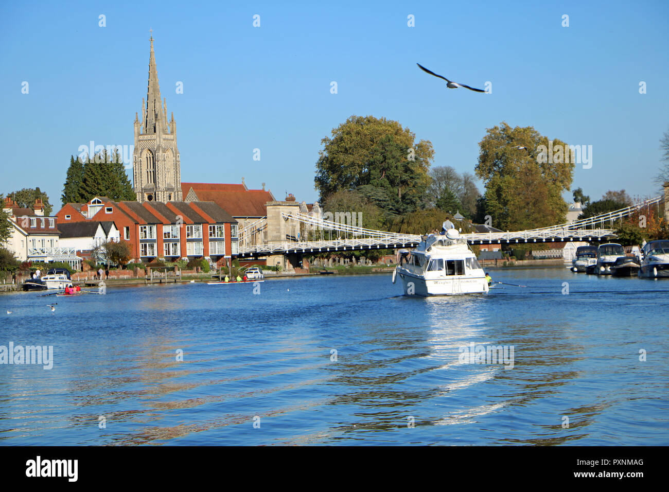 Una barca n il Tamigi di fronte a Marlow Bridge su una soleggiata giornata di ottobre Foto Stock
