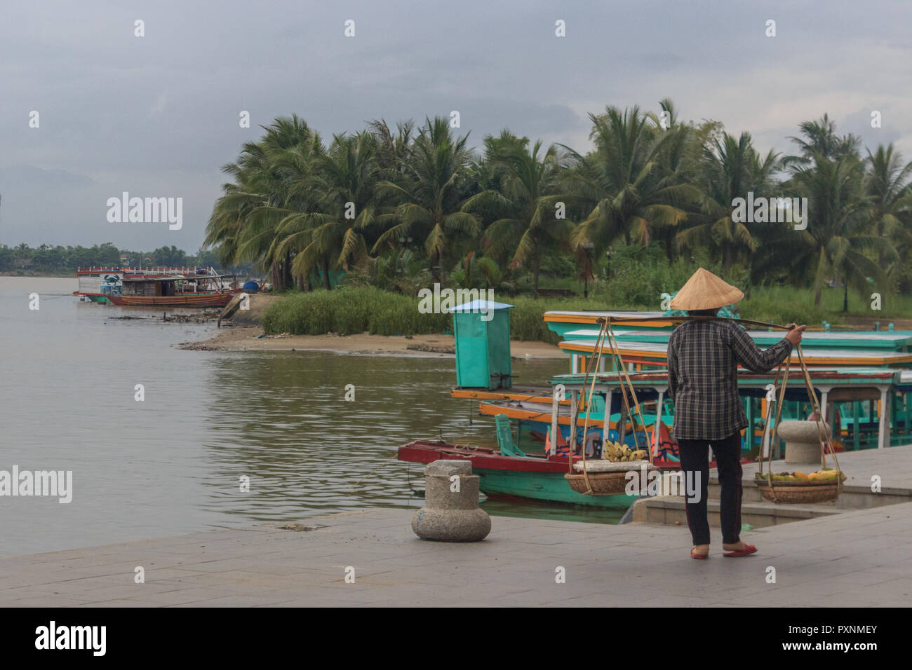 La vendita tradizionale lady presso la riva del fiume in Hoi An, Vietnam Foto Stock