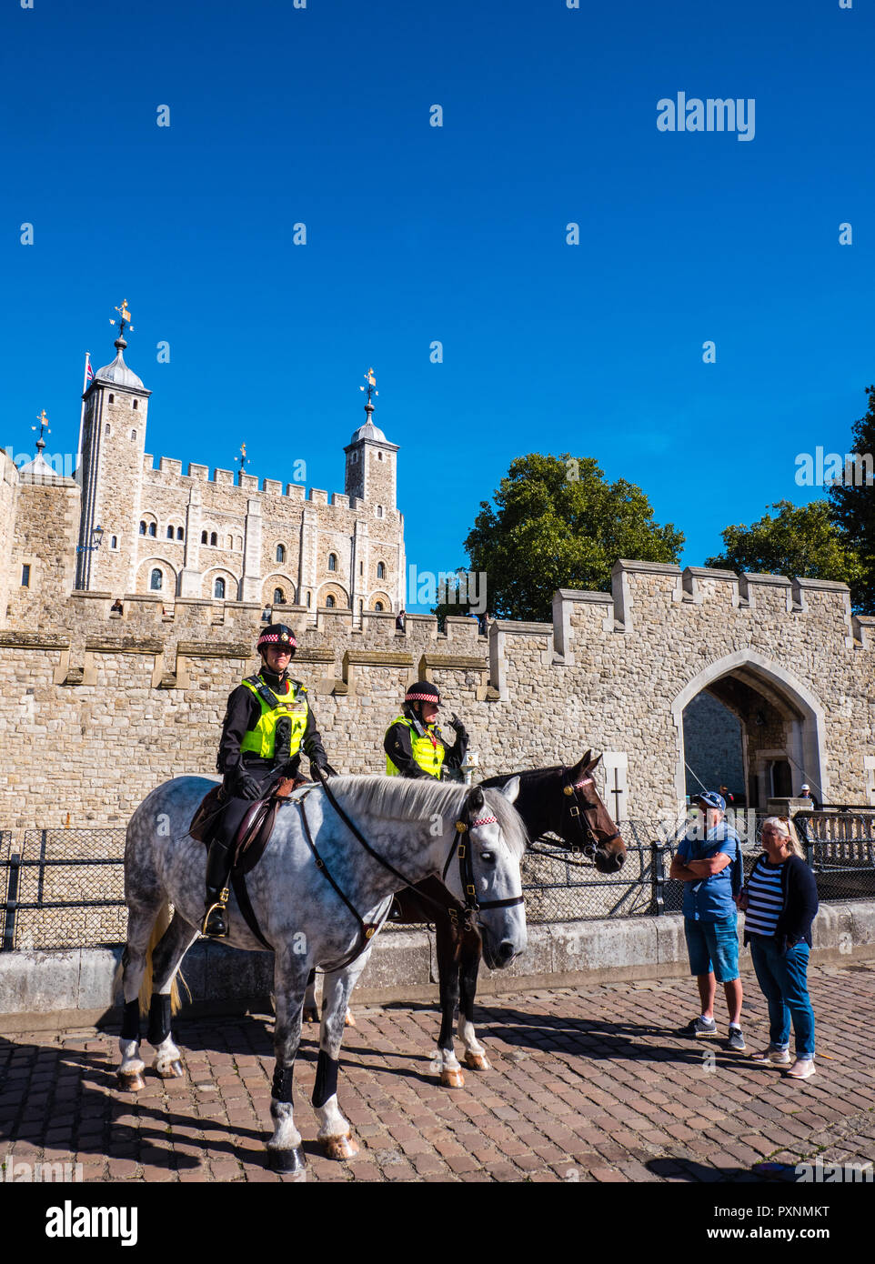 Donna cavallo di polizia ufficiali, fuori dalla Torre di Londra con i turisti, Londra, Inghilterra, Regno Unito, GB. Foto Stock
