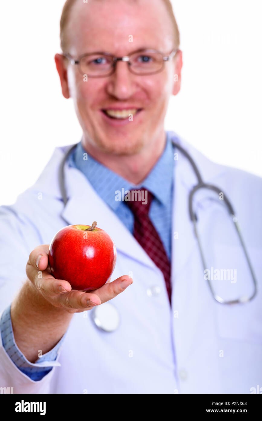 Studio shot di uomo felice medico sorridere mentre dando red apple w Foto Stock