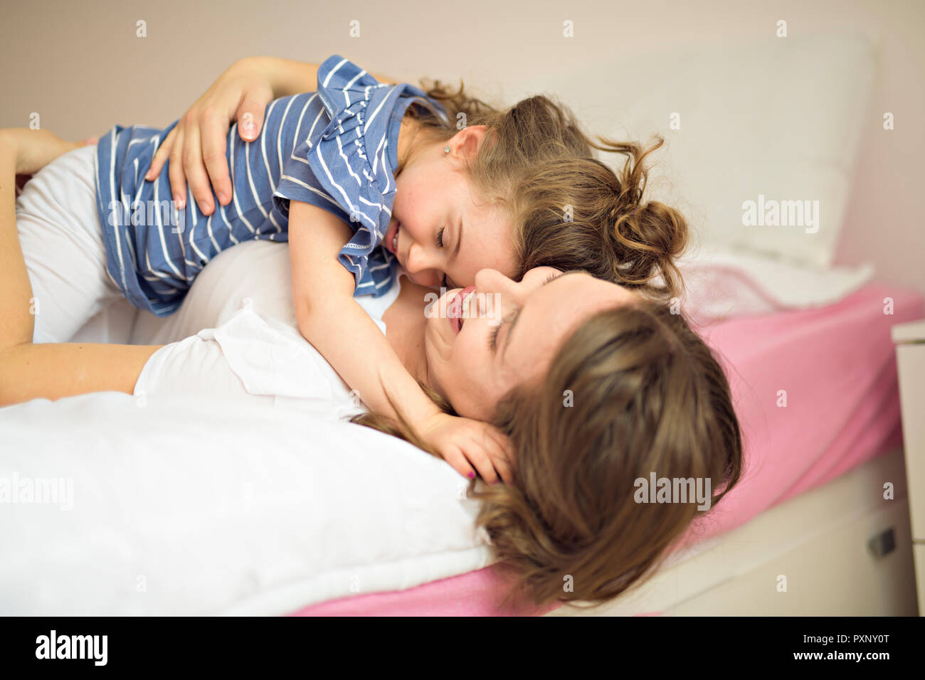 Madre e figlia godono nel letto di casa Foto Stock