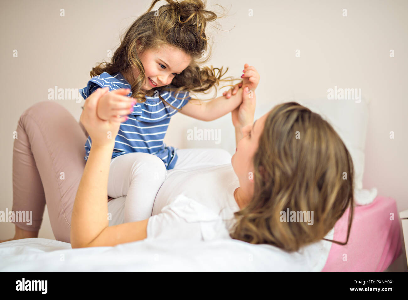 Madre e figlia godono nel letto di casa Foto Stock