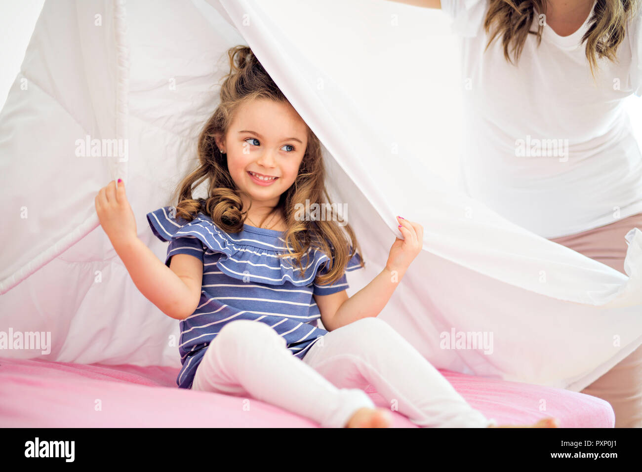 Ritratto di una ragazza sotto i coperchi dal foglio bianco Foto Stock