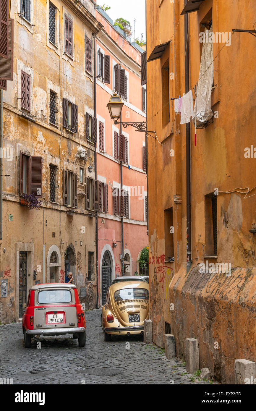 Le auto vecchie e colorate case antiche nel quartiere romano di Trastevere, Italia centrale. Foto Stock