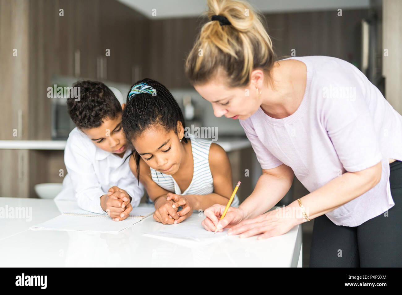 Madre scrivi nota sulla cucina tabl con i bambini Foto Stock