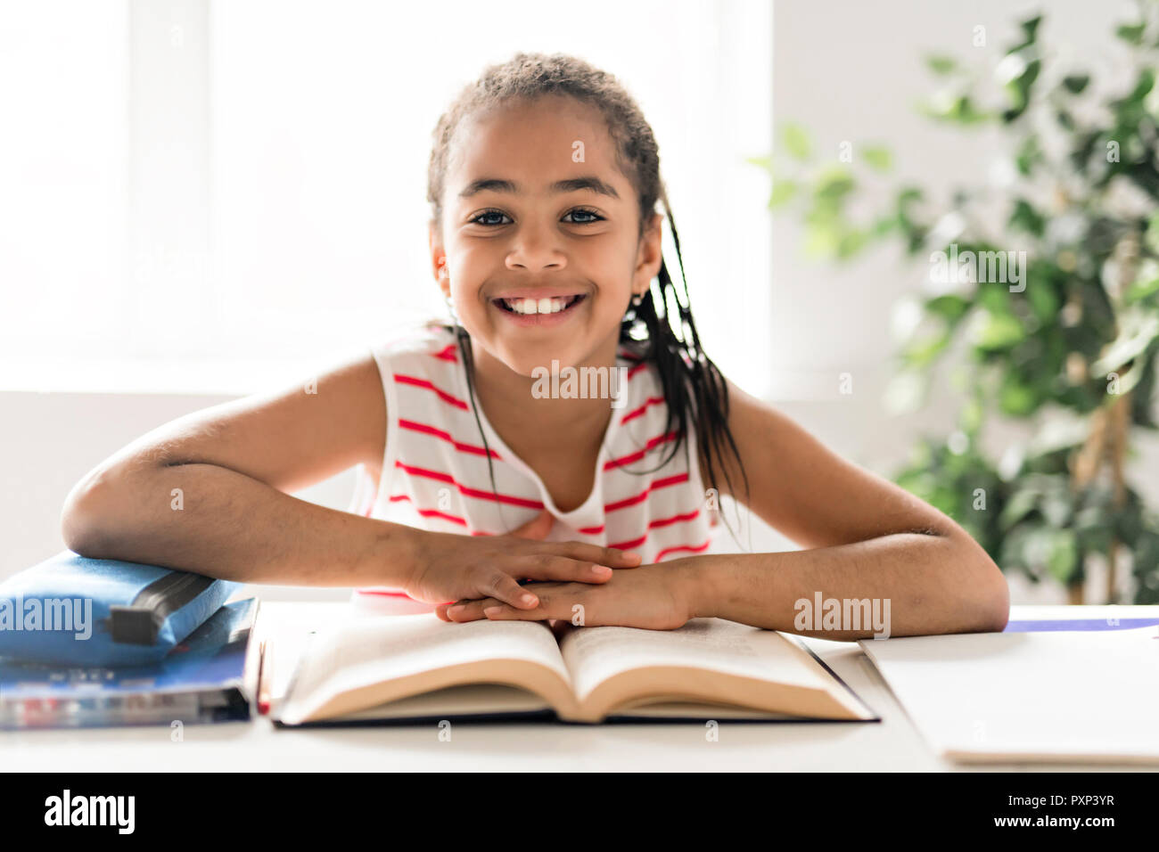 Una bella ragazza nera a fare i compiti a casa Foto Stock