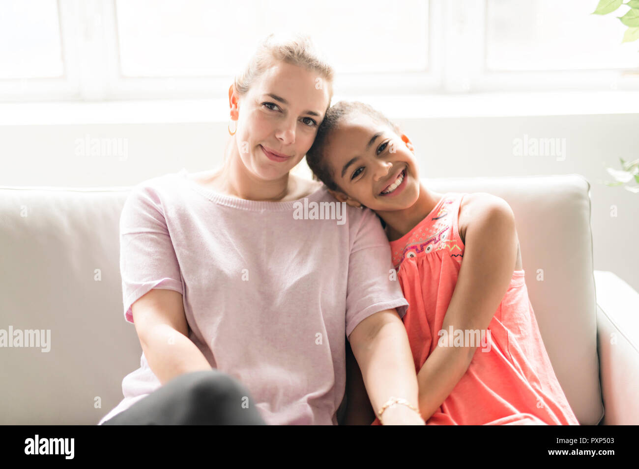 Madre con bambino nero ragazza sul divano Foto Stock