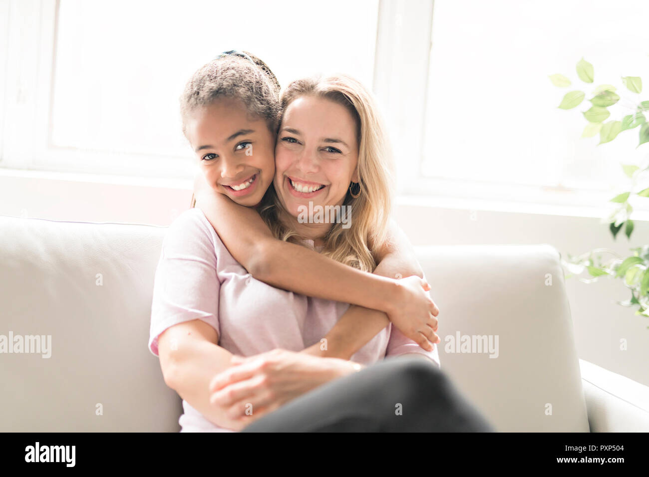 Madre con bambino nero ragazza sul divano Foto Stock