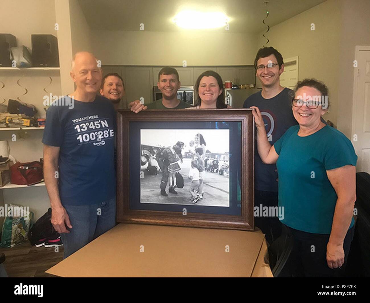 La famiglia di Elliott pone con loro 1985 ritratto di famiglia che mostra pensionati Lt. Col. Gary, estrema sinistra, accolto torna alla Moody Air Force Base, Ga., dopo una distribuzione, da sua moglie e figli, 18 giugno 2017. Dopo essere stato informato di questo ritratto, la famiglia Elliot ricerca per la foto per circa vent'anni. Al ricevimento di ordini da Moody nel 2015, il Mag. Jonathan Elliott, 23d disponibilità logistica Squadron direttore delle operazioni, ha continuato a cercare la snapshot, ottenendo nel 2016. Foto Stock