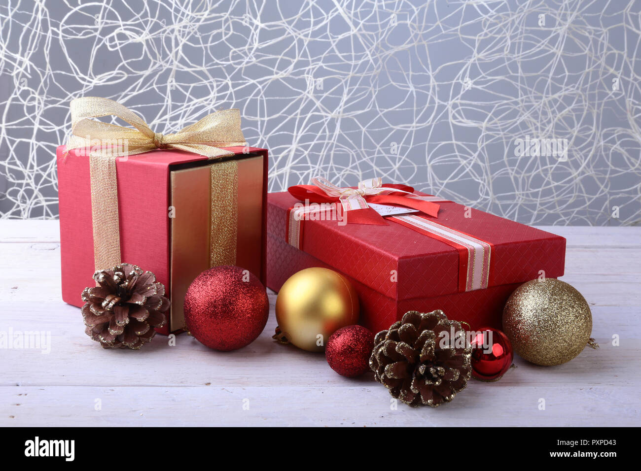 Confezioni regalo con fiocco e palle di Natale su uno sfondo di legno. Decorazione Foto Stock